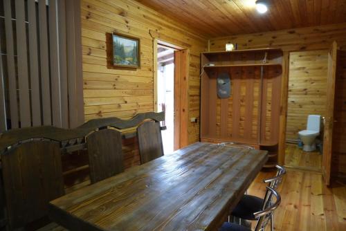 a wooden dining room with a wooden table and chairs at Veranda in Mykulychyn