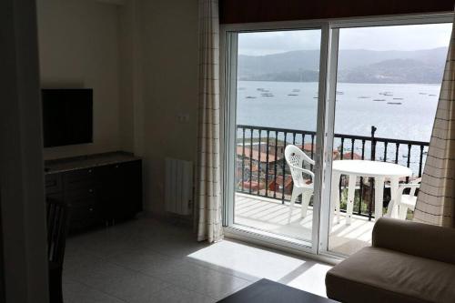 a living room with a balcony with a view of the water at Aireluz, miradoiro á ría in Raxo