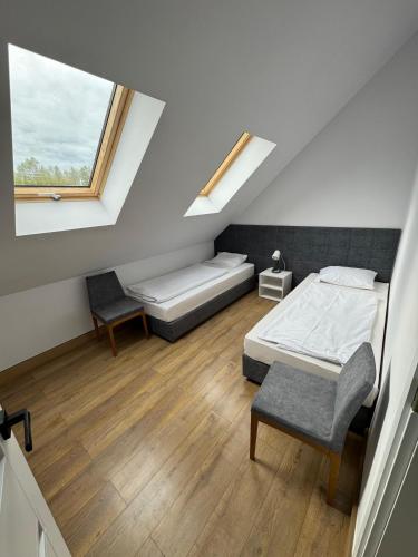 a bedroom with a bed and a chair and a window at Domki wypoczynkowe LAS in Śliwice