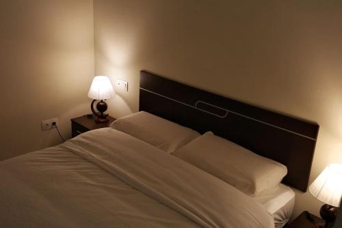 sypialnia z białym łóżkiem z 2 lampami w obiekcie Aireluz, miradoiro á ría w mieście Raxo
