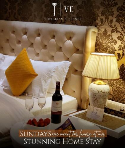 a hotel room with a bed with a bottle of wine and glasses at Victorian Elegance Luxury Stays in Amritsar