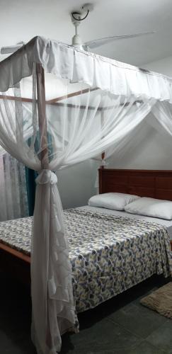 een slaapkamer met een hemelbed bij Tawali apartments in Mombasa