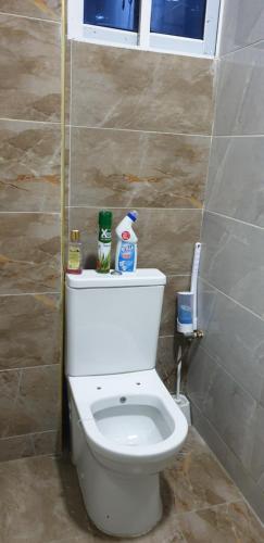 een badkamer met een wit toilet in een kamer bij Tawali apartments in Mombasa