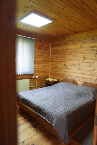 a bedroom with a bed in a wooden cabin at Veranda in Mykulychyn