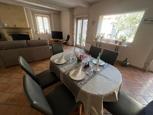 a dining room with a long table and chairs at Le colibri bleu in Argeliers
