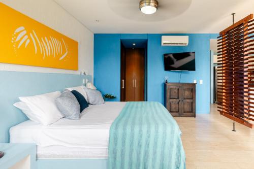 um quarto com uma cama branca e paredes azuis em Heart of Santa Marta / Designerloft / Rooftop Pool em Santa Marta