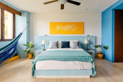 um quarto com uma cama com uma pintura laranja por cima em Heart of Santa Marta / Designerloft / Rooftop Pool em Santa Marta