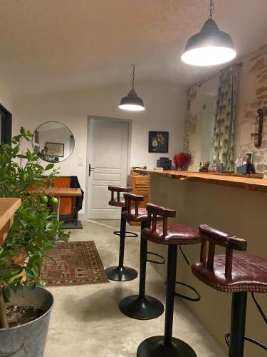 une pièce avec des tabourets et un bar avec un comptoir dans l'établissement La Maison du Parc, à Saint-Vite