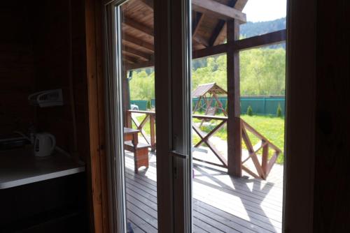 a door to a porch with a view of a deck at Veranda in Mykulychyn