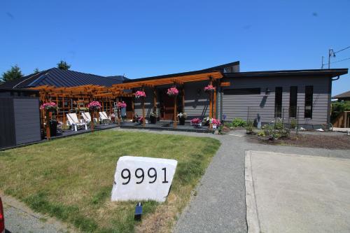a house with a sign in the front yard at EdgeWater Chemainus in Chemainus