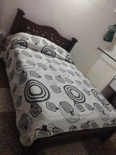 - un lit avec une couette en noir et blanc dans l'établissement Habitación, à Valledupar