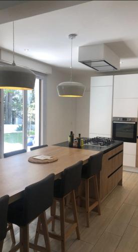 une cuisine avec une grande table en bois et des chaises dans l'établissement Charmant appartement avec jardin à 10 mn du Palais, à Cannes