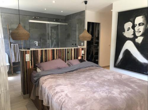 - une chambre avec un lit et une grande peinture murale dans l'établissement Charmant appartement avec jardin à 10 mn du Palais, à Cannes