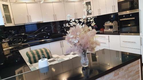 a kitchen with a vase of flowers on a counter at Kuca in Sarajevo