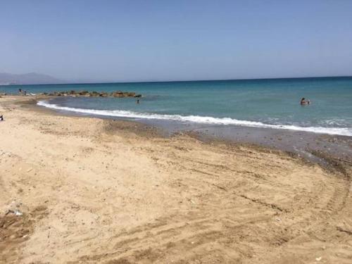 a beach with people swimming in the ocean at Villa Hidra near Cefalù in Buonfornello