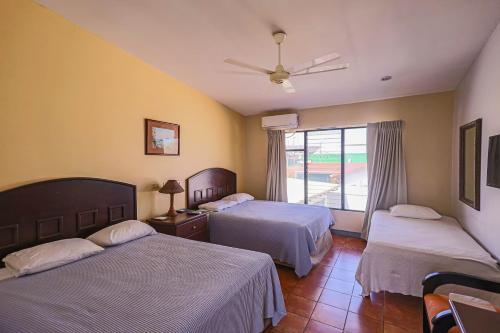 Habitación de hotel con 2 camas y ventana en Hotel Caña Brava Inn en Cañas