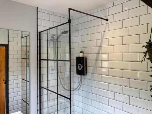a bathroom with a shower with a soap dispenser on the wall at Rustic Top Floor West End Pad With Balcony, Parking next to Byers Road, Aston Lane, Glasgow Uni in Glasgow