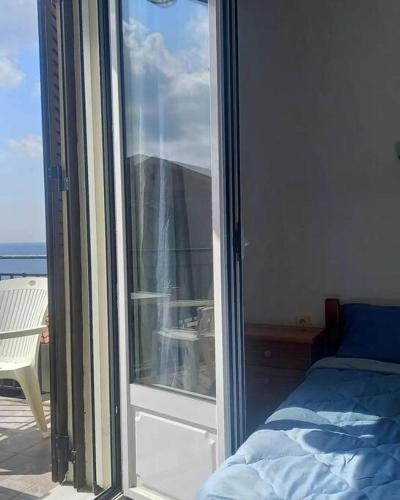 a bedroom with a sliding glass door to a balcony at Vista del Mare Rooms 2 in Agios Ioannis Kaspaka