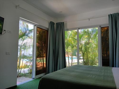 sypialnia z łóżkiem i dużymi przesuwnymi szklanymi drzwiami w obiekcie Zodiaco in Las Terrenas w mieście Las Terrenas