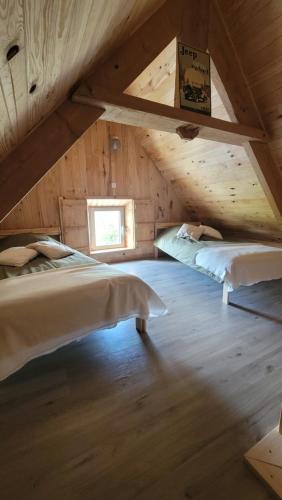 BrévandsにあるGîte au cœur du ddayのベッドルーム(ベッド2台付)が備わる屋根裏部屋です。
