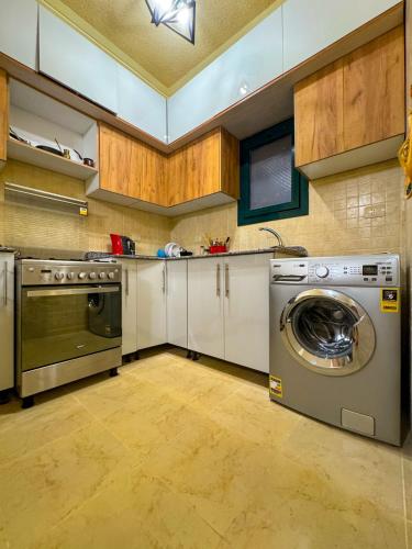 a kitchen with a washing machine and a dishwasher at la hacienda 2 bedroom in Ras Sedr