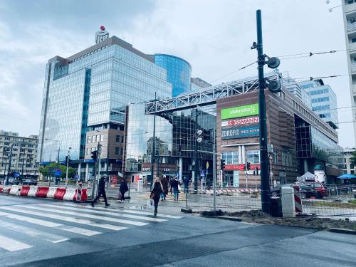 a group of people crossing a street in a city at Olivia Apartments - Słoneczny apartament w centrum Warszawy, Plac Unii Lubelskiej, Łazienki Królewskie, Pole Mokotowskie - 24h check-in in Warsaw