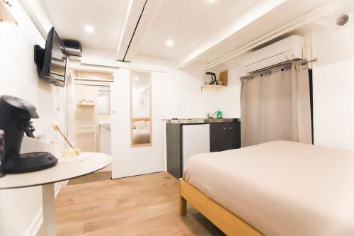 une chambre avec un lit et une table et une cuisine dans l'établissement Studio palais des festivals Croisette, à Cannes