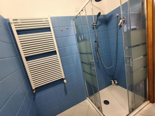 een blauwe betegelde badkamer met een douche en een glazen deur bij Le Due Isole in Bologna