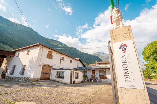 um sinal para um hotel em frente a um edifício em Historical Wine Retreat - 5 min drive from Tirano em Villa di Tirano