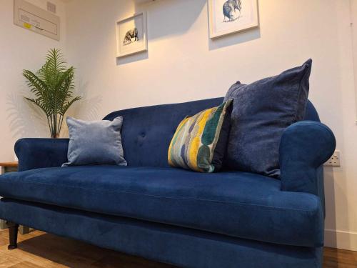 a blue couch with pillows on it in a living room at La'al Lodge in Kendal (The Gateway to the Lakes) in Kendal