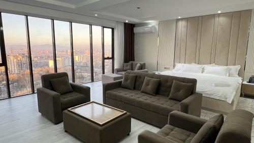 una camera con letto, divano e sedie di Firdavsi Hotel a Dushanbe