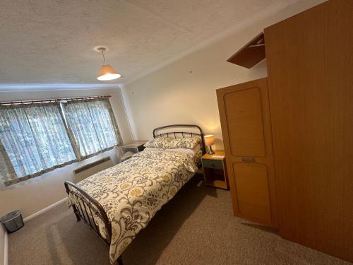 a bedroom with a bed and a desk and a window at 10 Edney Court in Earley