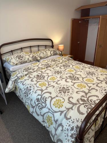 a bedroom with a bed with a blue and yellow comforter at 10 Edney Court in Earley