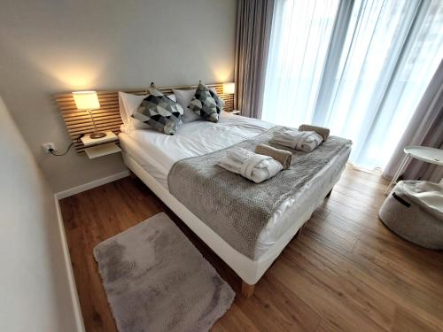 a bedroom with a large bed with towels on it at Hanza Tower STETT-INN Business & Holiday in Szczecin