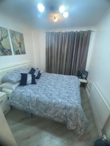 - une chambre avec un lit et une couette bleue et blanche dans l'établissement 2 bedroom apartment in Maida Vale, à Londres