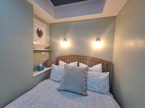 a bedroom with a bed with two pillows and two lights at La'al Lodge in Kendal (The Gateway to the Lakes) in Kendal