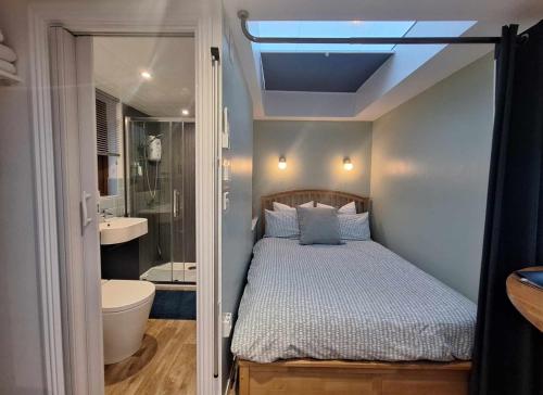 a small bedroom with a bed and a bathroom at La'al Lodge in Kendal (The Gateway to the Lakes) in Kendal