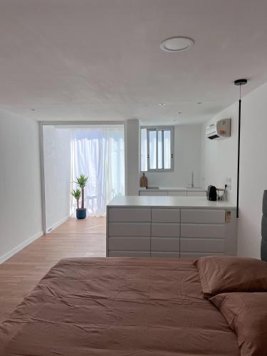 - une cuisine blanche avec un grand lit dans une chambre dans l'établissement Superbe, face à la mer, balneo, rétroprojecteur, à Canet