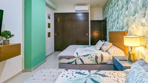 a bedroom with two beds and a table with a lamp at XMX Pacific Pearl in Mazatlán