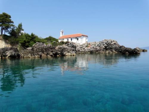 a house on a small island in the water at Green and Blue View in Elliniká