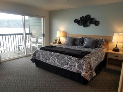 a bedroom with a large bed and a balcony at Sq Orca Oasis in Port Townsend