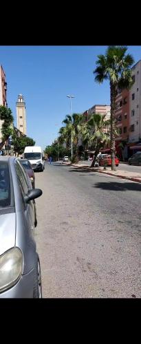 un coche aparcado al lado de una calle con palmeras en Appartement entier de 4 pièces à 10 minutes de morroco mall, en Casablanca