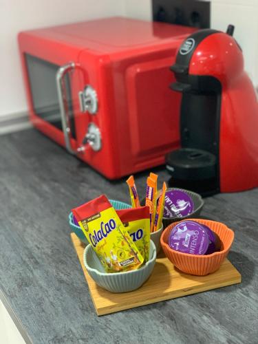 a counter with bowls of snacks and a red toaster at Apartamentos Talao in San Esteban de Pravia