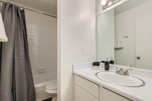 uma casa de banho branca com um lavatório e um espelho em Your 2B Getaway Steps to Dtwn - Sleeps 6 - Pool, Prkg em Austin