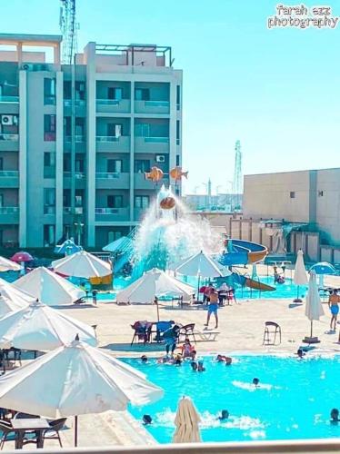 een zwembad met een waterpark met mensen erin bij قريه جراند هليز in Dawwār ‘Abd Allāh