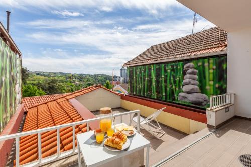 a balcony with a table with food and drinks on it at Porta 116 in Vila Real