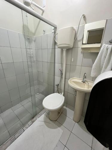 a bathroom with a toilet and a sink and a shower at Pousada Vila do Penedo in Penedo