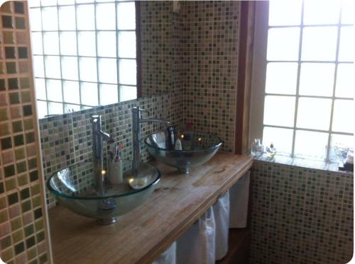 une salle de bains avec trois lavabos sur un comptoir en bois dans l'établissement Maison avec piscine et grande terrasse -Sud Landes, à Tosse