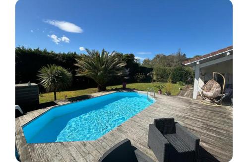 une piscine sur une terrasse à côté d'une maison dans l'établissement Maison avec piscine et grande terrasse -Sud Landes, à Tosse