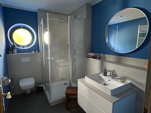 een badkamer met een douche, een wastafel en een spiegel bij Ferienwohnung Feldblick in Schwerin